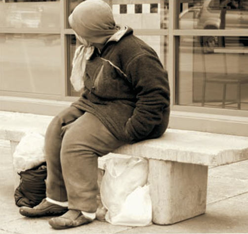 Person sitting on a benchwith multiple bags